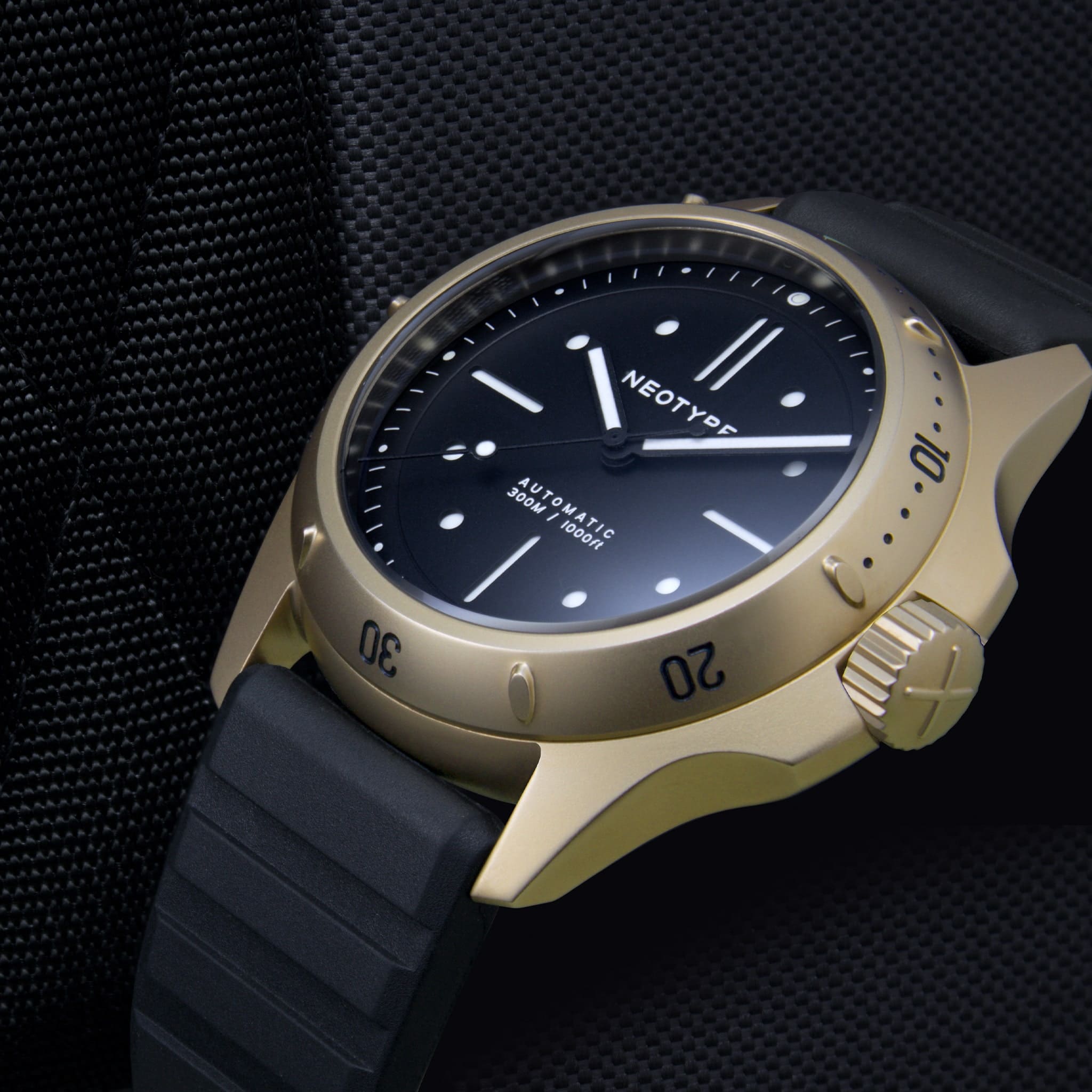 Bracelet FKM de Neotype Watches en caoutchouc fluocarboné noir, photographié de manière à montrer les détails de l'emballage et sa présentation élégante sur une surface claire.